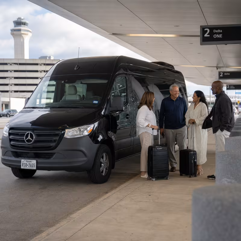 Group boarding a white charter bus for Airport Transportation transportation in Dallas