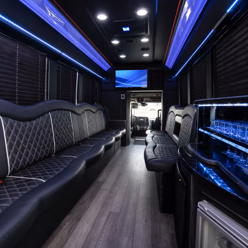 Party bus interior with wraparound leather seating and LED lighting in Dallas