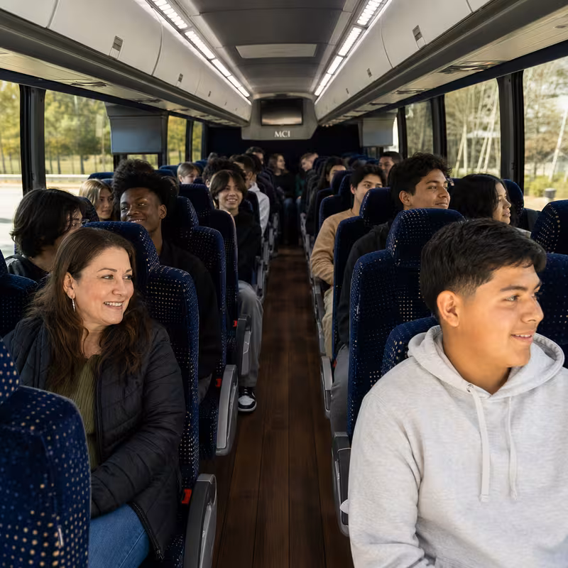 Group boarding a white charter bus for School Transportation transportation in Dallas