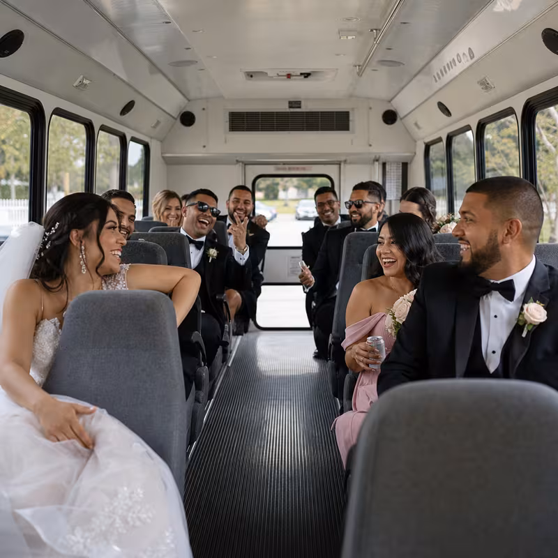 Group boarding a white charter bus for Wedding Transportation transportation in Dallas